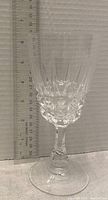 Single large crystal wine glass with vertical and faceted cut design placed next to a ruler showing a height of about 20 cm.