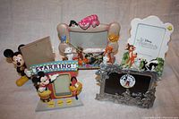 Five Disney picture frames shown together on cloth surface including Aristocats, Bambi, and Mickey themed frames