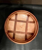 Top view of the handmade wooden bowl showing the light and dark wood plaid pattern inside.