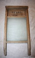 Front view of wooden washboard showing Pearl Canadian Woodenware stamp and glass scrubbing surface