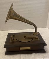 Front and side view of the phonograph style music box showing wooden base, brass horn, and tonearm.