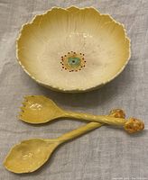 Photo showing the matching yellow lacquered salad serving fork and spoon with flower-shaped handles alongside the buttercup bowl.