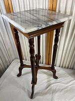 Full view of the 1940s French marble top side table showing the square marble top and turned wooden legs with stretcher base.