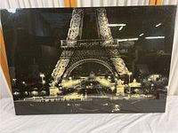 Front view of glossy wrapped print showing illuminated Eiffel Tower at night.