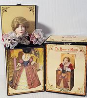 Photo of music box figure of The Queen of Hearts with her painted dress and accessories alongside the collectible box featuring box artwork and title.