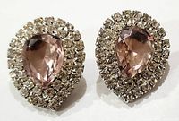 Front view of both vintage teardrop clip-on earrings showing light pink center stone surrounded by clear rhinestones.