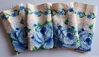 Four folded face cloths laid horizontally, showing overall set and pattern.