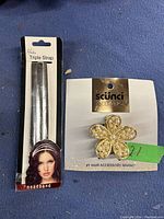 Photo of two new girls hair accessories: a triple silver strap headband and a gold-tone flower-shaped hair clip with rhinestones by Scünci Collection.
