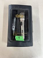 Boxed pair of QFX microphones, visible through the clear plastic window marked QFX Super Professional Microphone M-308, one black and one silver microphone