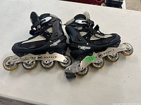 Pair of women's inline roller blades on white surface showing side and top view, highlighting wheels and boot design.