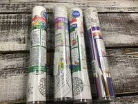 Four tubes of adult colouring posters with colour pencils included, displayed on wooden surface