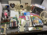 Full view of all crafting supplies laid out, showing wooden figures, paints, crayons, and accessories
