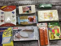 Photo of various clay packages laid out on wooden background including Instant Tac, Sculpey, Plastimodel, and more.