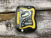 Top view showing front controls and display of yellow and black Sony Sports cassette player, model VH-FS220 with Mega Bass and 30 presets.