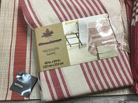 Close up of the folded tablecloth package showing size 60 x 84 inches and red and white stripe pattern