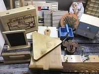Overview showing wooden collection box, small cabinet, cutting boards, chalkboard, butterfly decoration, floral plaque, and other wooden craft items.