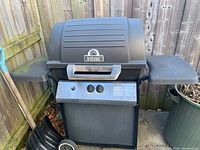 Front view of Broil Mate propane BBQ grill with stand and shelves, showing control panel and handle.