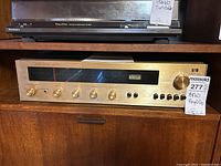 Front view of the BFW amplifier showing the gold faceplate with multiple control knobs and a tuning dial.