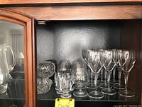 Shelf display of crystal glasses including wine glasses, cognac glasses, shot glasses, crystal candy dish and bowl.