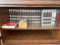 Funk & Wagnalls encyclopedias and various dictionaries on a wooden shelf, showing full set of volumes 1 through 30 and additional books on the side