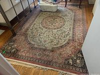 Area rug under a metal bed frame showing entire length and width, with folded laundry basket on top.