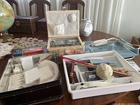 Overall view of sewing box and additional sewing items along with heating pad and knitting needles.