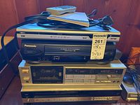 Nextech DVD player on top of Panasonic and Zenith VHS players with Sony cassette deck beneath