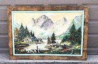 Full view of framed oil painting showing mountain landscape with cabin, trees, lake, and mountains in background