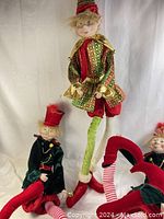 Photo showing all three large posable elf dolls in various festive outfits, sitting and standing poses