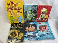 Front view of six books titled The Kids Joke Book, A Single Shard, Marley, Jason & The Argonauts, Stranded, and Unschooling.