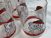 Close-up image showing the polar bear illustration wearing green and red winter hats with a red border near the base of the plate.