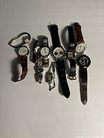 All watches arranged in a group showing various band materials and face designs