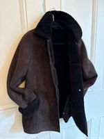 Full front view of the brown Danier sheepskin coat on hanger showing shearling collar and inside lining.
