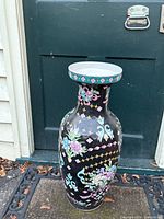 Front view of the large Chinese floral vase showing colorful floral and butterfly motifs on a black background with teal rim.