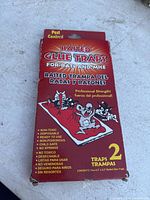 Front side of red box of baited glue traps, showing product info and illustrations of rodents.