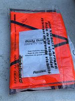 Photo of unopened package showing neon orange vest with reflective tape and BodyGuard Safety Gear branding.