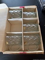 Box of six clear crystal mugs with diamond cut pattern with handles, packed in cardboard.