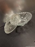 Side view of the crystal glass candy dish with lid, showing detailed embossed designs and pedestal base