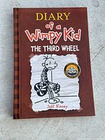 Front cover of 'Diary of a Wimpy Kid: The Third Wheel' book showing the main character illustration and title.