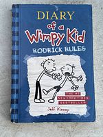 Front cover of Diary of a Wimpy Kid: Rodrick Rules hardcover book showing the title, author Jeff Kinney, and illustration of two cartoon characters.