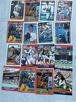 Photo showing a mix of football and baseball cards including Jim Adduci, Eric Plunk, Kelly Dennett, and Kal Daniels baseball cards plus football cards of Rob Brown and others.