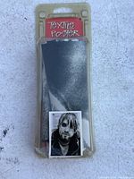 Plastic packaging labeled 'TEXTILE POSTER' with the folded black and white textile poster inside, showing part of a man's grayscale photographic image.