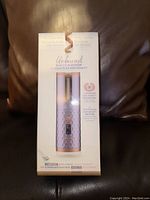 Front view of the boxed Unbound cordless auto-curler showing product name, key features, and image of the device with diamond pattern handle and rose gold accents.