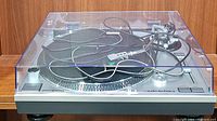 Front view of Audio-Technica turntable with dust cover closed and cables on platter