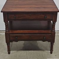 Front view of Broyhill wooden 2-drawer end table in dark stain, showing turned legs and drawer fronts with round pulls.