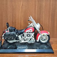 Front view of the red and black Harley-Davidson motorcycle desk phone on black base with nameplate.
