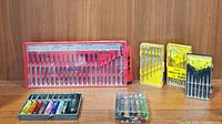 Overall view of 5 screwdriver sets including large red case, yellow and black smaller cases, and compact colored handle set
