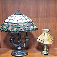 Both stained glass lamps shown together, highlighting size and color differences