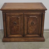 Front view of wooden server cabinet showing closed doors and top surface