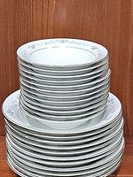 Stack of 12 Wyndham dessert bowls with floral rim pattern, white porcelain.